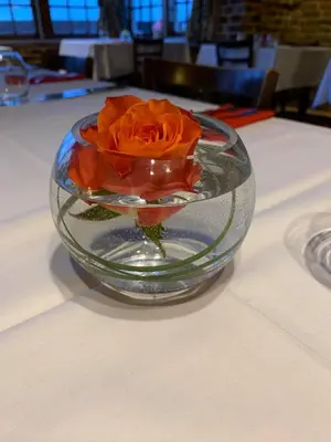 a orange rose in a glass bowl on a table at Ye Olde White Harte Hotel in Burnham on Crouch