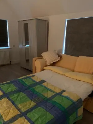 a living room with a couch and a bed at Appletree Cottages in Mildenhall