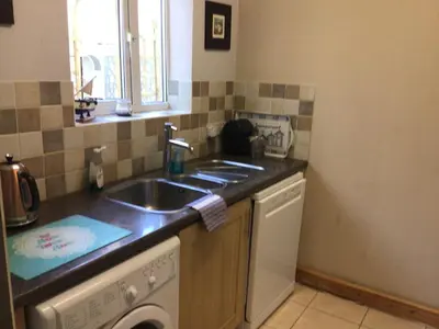 a kitchen with a sink and a washing machine at The Bakehouse in Harwich
