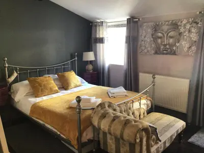 a bedroom with a large bed with a head on the wall at The Bakehouse in Harwich