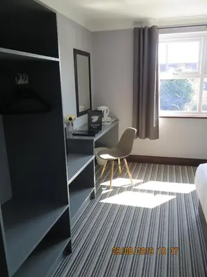 a room with a desk and a chair and a window at Oyster Fleet Hotel in Canvey Island