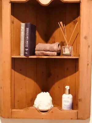 a wooden shelf with towels and other items on it at The Blue Cow in Fenstanton