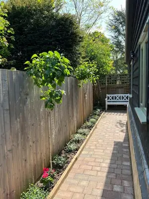 a garden with a fence and a bench in a yard at The Nest-Cambridge in Cambridge
