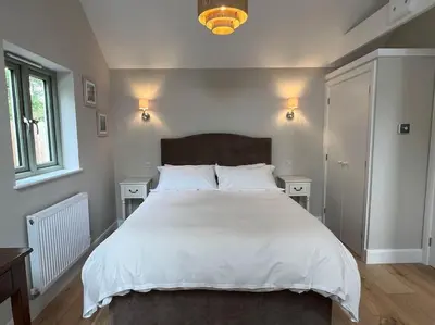a bedroom with a large white bed with two night stands at The Nest-Cambridge in Cambridge
