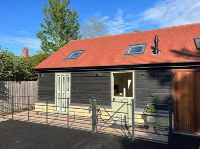 a small wooden house with a red roof at The Nest-Cambridge in Cambridge