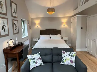a bedroom with a bed and a couch and a table at The Nest-Cambridge in Cambridge
