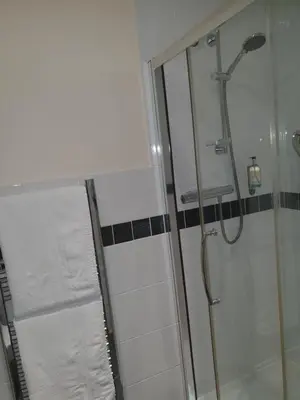 a bathroom with a shower with a glass door at The Harp Freehouse and Guesthouse in Ipswich