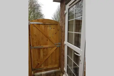 a wooden door with a window next to a building at Cosy, self contained annex in Cambridge