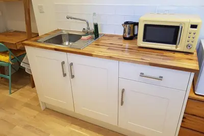 a kitchen counter with a sink and a microwave at Cosy, self contained annex in Cambridge