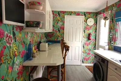 a kitchen with colorful wallpaper and a table with chairs at Lakeland Lodge with private Hot Tub and fishing in Hatfield Peverel