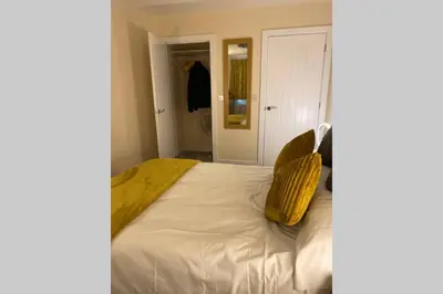 a bedroom with a bed with two yellow pillows on it at 13 The Grosvenor, luxury flat, central Newmarket, in Newmarket