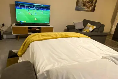 a living room with a flat screen tv and a couch at 13 The Grosvenor, luxury flat, central Newmarket, in Newmarket