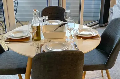 a table with plates and wine glasses on it at 13 The Grosvenor, luxury flat, central Newmarket, in Newmarket