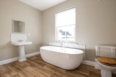 a bathroom with a tub and a sink and a toilet at The Dower Lodge in Sizewell