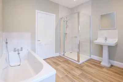a bathroom with a tub and a sink and a shower at The Dower Cottage in Sizewell