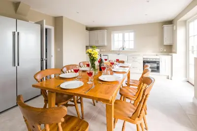 a kitchen and dining room with a wooden table and chairs at The Dower House in Sizewell