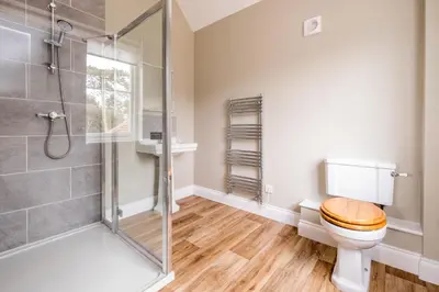 a bathroom with a toilet and a glass shower at The Dower House in Sizewell