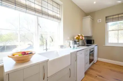 a white kitchen with a bowl of fruit on the counter at The Dower Retreat in Sizewell