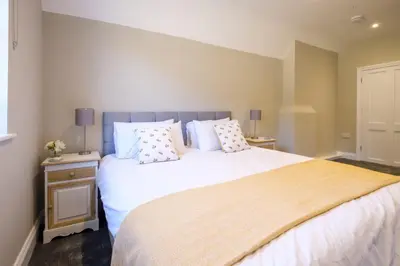 a bedroom with a large bed with white sheets and pillows at The Dower Retreat in Sizewell