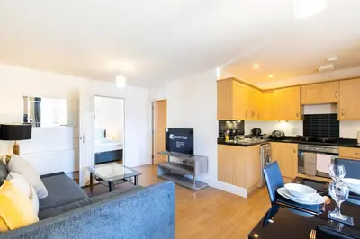 a living room with a couch and a kitchen at Velvet 1-bedroom apartment, Clockhouse, Hoddesdon in Hoddesdon