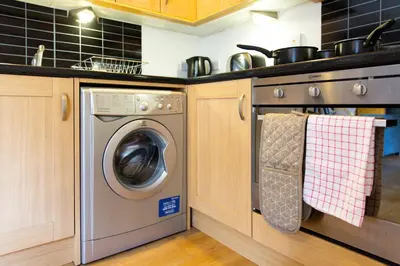 a kitchen with a washing machine and a sink at Velvet 1-bedroom apartment, Clockhouse, Hoddesdon in Hoddesdon