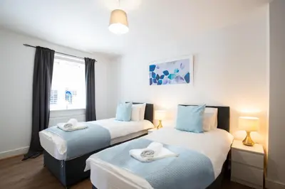 two twin beds in a room with a window at Velvet 1-bedroom apartment, Clockhouse, Hoddesdon in Hoddesdon