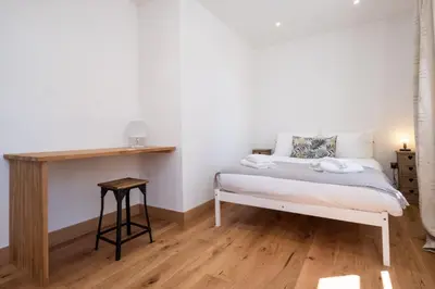 a bedroom with a bed and a wooden table at Three Tuns Apartments - Hazel - Aldeburgh Coastal Cottages in Pettistree