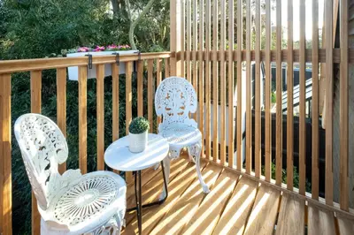 two chairs and a table on a wooden deck at The Bay Tree Studio in Thorpeness