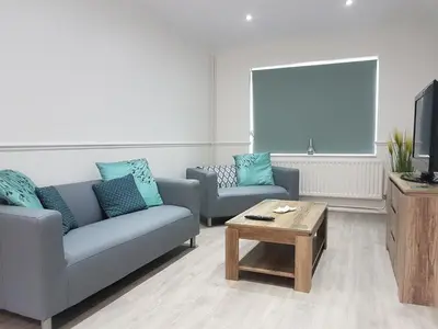 a living room with two couches and a coffee table at Rayleigh House in Rayleigh