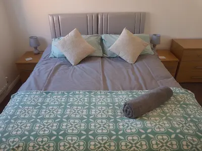 a bed with a blanket and pillows on it at Rayleigh House in Rayleigh