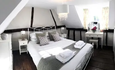 a bedroom with a white bed with two towels on it at Millie's Cottage in Finchingfield
