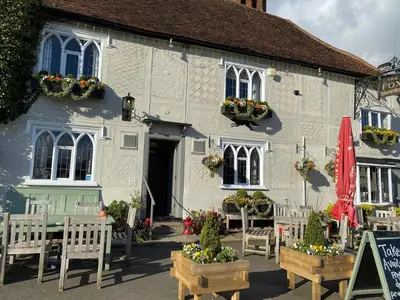 a white building with tables and chairs in front of it at Millie's Cottage in Finchingfield