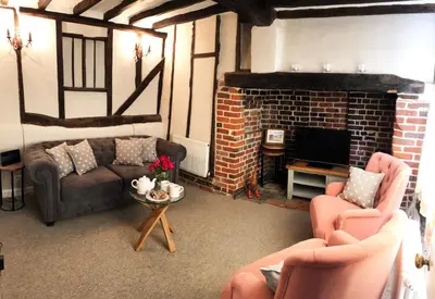 a living room with two couches and a fireplace at Millie's Cottage in Finchingfield