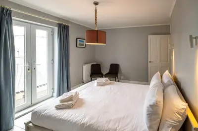 a bedroom with a large white bed and a window at Crags Nest in Aldeburgh