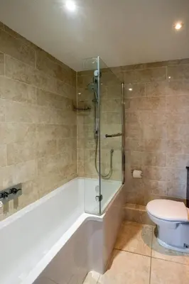 a bathroom with a shower and a toilet and a tub at Crags Nest in Aldeburgh