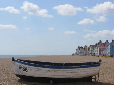 a boat sitting on the shore of a beach at Crags Nest in Aldeburgh