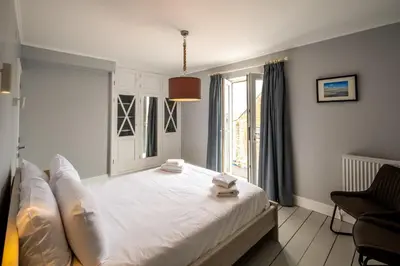 a bedroom with a large white bed with a window at Crags Nest in Aldeburgh
