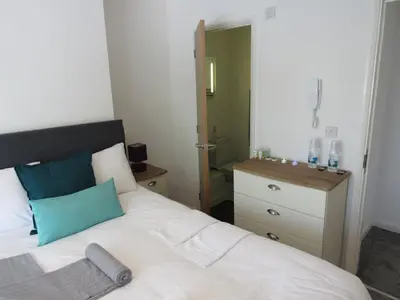 a bedroom with a white bed and a dresser at The Cambridge Suites - Tas Accommodations in Cambridge