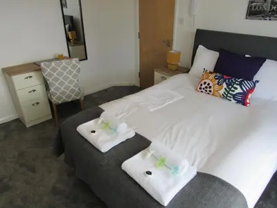 a bedroom with a large white bed with two towels at The Cambridge Suites - Tas Accommodations in Cambridge