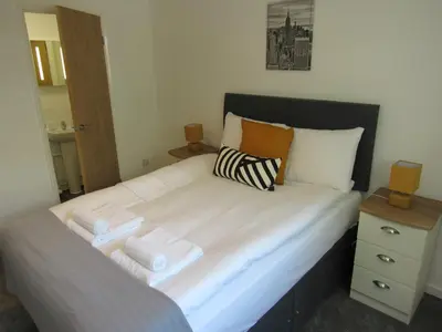a bedroom with a large bed with towels on it at The Cambridge Suites - Tas Accommodations in Cambridge