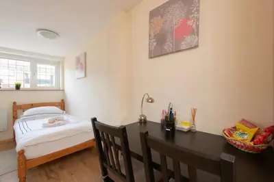 a bedroom with a desk and a bed and a table at Simple Private Studio in Harold Wood