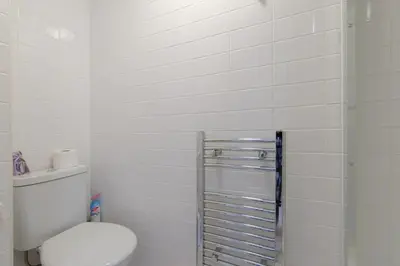 a white bathroom with a toilet and a shower at Simple Private Studio in Harold Wood