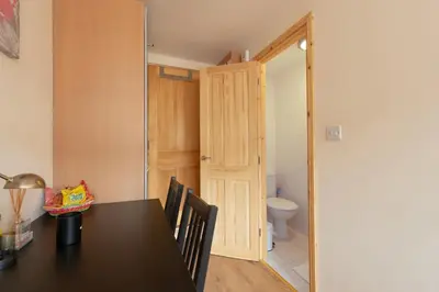 a dining room with a table and a toilet at Simple Private Studio in Harold Wood