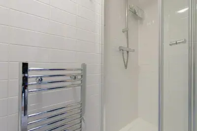 a shower with a glass door in a bathroom at Simple Private Studio in Harold Wood