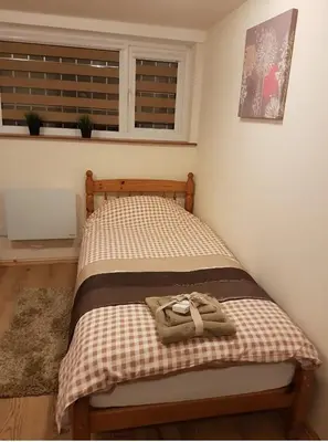 a bed with two towels on it in a room at Simple Private Studio in Harold Wood