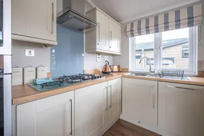 a kitchen with white cabinets and a stove top oven at Hunky-Dory - Aldeburgh Coastal Cottages in Sizewell