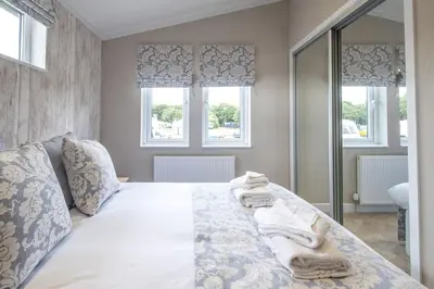 a bedroom with a bed with towels on it at Hunky-Dory - Aldeburgh Coastal Cottages in Sizewell