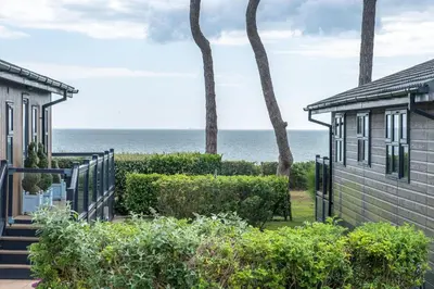 a view of the ocean from between two houses at Hunky-Dory - Aldeburgh Coastal Cottages in Sizewell