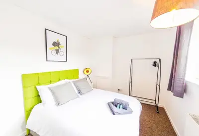 a bedroom with a white bed with a green headboard at 4 Bed - 2 Baths 1 Walk In Shower Lots Of Parking in Ipswich