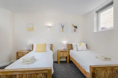 two twin beds in a room with a window at 2 Bedroom City Centre Townhouse - with Parking in Cambridge